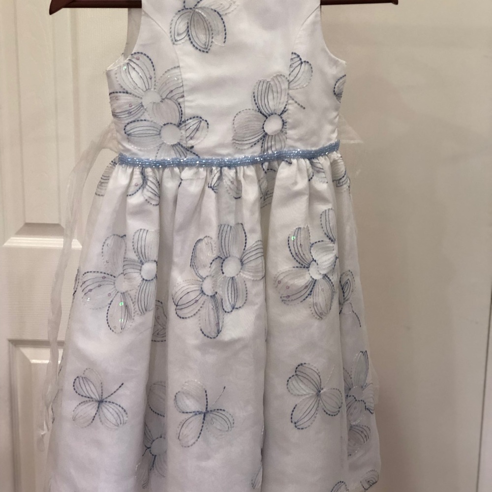 White dress with blue design and ribbon belt.